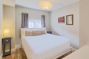 ein Schlafzimmer mit einem großen weißen Bett und einem Fenster in der Unterkunft Host & Stay - Roper Road in Canterbury