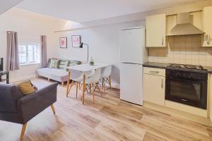 eine Küche und ein Wohnzimmer mit einem Tisch und einem Sofa in der Unterkunft Host & Stay - Roper Road in Canterbury