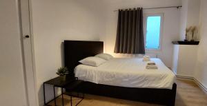 una camera da letto con un letto con lenzuola bianche e una finestra di The View - spacious 2 bdr appt in with view ad Anversa