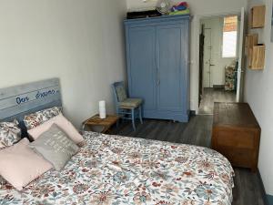 1 dormitorio con 1 cama y armario azul en LES BAIGNEUSES en Dieppe