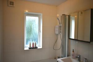 a bathroom with a shower and a sink and a window at Balcony Breeze - Reading City Centre in Reading