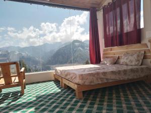 a bedroom with a bed and a large window at Stargazing Glass Lodge Himachal Pradesh Thachi in Mandi