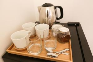 a tray with glasses and a coffee pot on a table at Camden Town Self Check-in Luxury Rooms in London