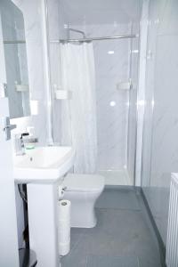 a white bathroom with a toilet and a shower at Camden Town Self Check-in Luxury Rooms in London