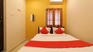 a bedroom with a large bed with red pillows at Hotel Park Sivagangai in Sivaganga