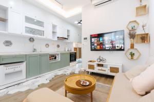 a kitchen with green cabinets and a tv on the wall at Pearland -D'Eldorado Apartment in Hanoi