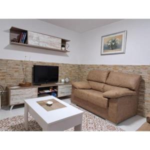 a living room with a couch and a tv at Meraki in Finisterre
