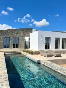 a villa with a swimming pool in front of a house at Egeo Paros in Kampos Paros