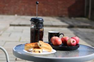 una mesa con un plato de manzanas y una taza de café en Comfy 2-Bedroom House in Parkgate - Ideal for Contractors/Business Travellers en Rotherham