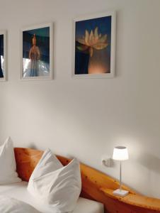 - une chambre avec un lit et deux photos sur le mur dans l'établissement Lorenzhof by JULKA - self checkin, à Ledenitzen