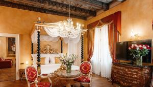 プラハにあるAlchymist Grand Hotel and Spa - Preferred Hotels & Resortsのベッド、テーブル、椅子が備わる客室です。