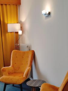a yellow chair in a room with a lamp at Lorenzhof by JULKA - self checkin in Ledenitzen