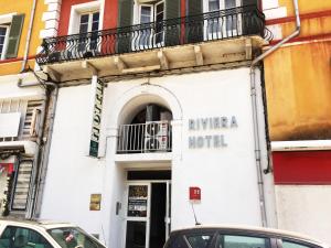 um edifício de hotel com carros estacionados em frente em Hotel Riviera em Bastia