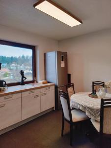cocina con mesa, nevera y ventana en Lorenzhof by JULKA - self checkin, en Ledenitzen