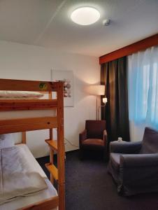 - une chambre avec des lits superposés et une chaise dans l'établissement Lorenzhof by JULKA - self checkin, à Ledenitzen