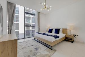 une chambre avec un lit et une grande fenêtre dans l'établissement LUXURIOUS ONE BEDROOM APARTMENTS IS DISTRICT 1, à Dubaï