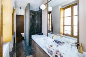 y baño con lavabo de mármol y espejo. en Ile Saint Louis & Direct River Views - CityApartmentStay en París