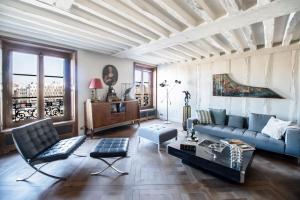a living room with a couch and a table at Ile Saint Louis & Direct River Views - CityApartmentStay in Paris