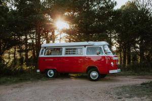 einem roten und weißen Van auf einer unbefestigten Straße in der Unterkunft Retro VW Kombi T2 Campervan in Hospitalet de Llobregat