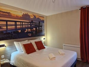 a bedroom with a bed with a painting of a pier at Hotel Eisenhower (ex King Hôtel) in Port-en-Bessin-Huppain