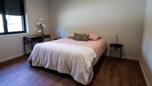 ein Schlafzimmer mit einem Bett, zwei Tischen und einem Fenster in der Unterkunft Maison 21 in Zutzendorf