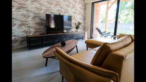 ein Wohnzimmer mit Sofas und einem Flachbild-TV in der Unterkunft Maison 21 in Zutzendorf