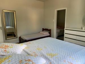 1 dormitorio con cama y espejo en Blumen Espaço "piscina privativa' en Blumenau