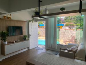 ein Wohnzimmer mit einer Schiebetür zum Pool in der Unterkunft Blumen Espaço "piscina privativa' in Blumenau