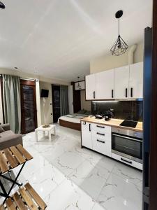 a kitchen with white cabinets and a bed at Aggelis Urban Life in Ioannina