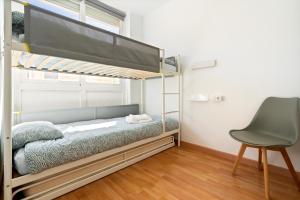 a bedroom with a bunk bed and a chair at Apartamento WELCS PDA-128-cerca del mar in Platja d'Aro