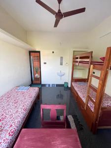 Zimmer mit 2 Etagenbetten und einem Deckenventilator. in der Unterkunft Countryside inn in Tiruvankod