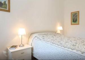 クエルチェタにあるApartment Michelangeloのベッドルーム1室(ベッド1台、ナイトスタンドのランプ付)