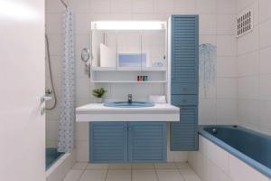 ein Badezimmer mit einem blauen Waschbecken und einer Badewanne in der Unterkunft ruim appartement aan zee in Ostende
