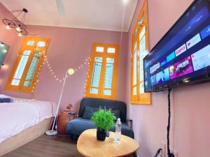a bedroom with a bed and a flat screen tv at MAY - YELLOW 02 - Phone 09756-59323 in Hanoi