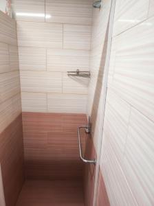 a shower stall in a bathroom with wooden tiles at Pronájem dřevěného mobilheimu Štít in Chlumec nad Cidlinou