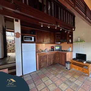 - une cuisine avec des placards en bois et un réfrigérateur blanc dans l'établissement La Villa de Petite Anse - Piscine, à Les Anses-d'Arlet