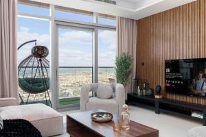 sala de estar con TV y ventana grande en 5 Stars Living Infinity Pool Burj Khalifa view, en Dubái