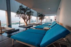 una fila de almohadas azules en una habitación con un árbol en 5 Stars Living Infinity Pool Burj Khalifa view, en Dubái
