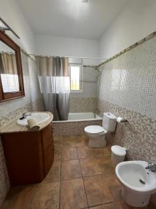 y baño con 2 aseos, lavamanos y bañera. en Chalet Piscina Privada Urbanización Roche Viejo, en Conil de la Frontera