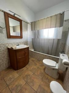 y baño con aseo, lavabo y espejo. en Chalet Piscina Privada Urbanización Roche Viejo, en Conil de la Frontera