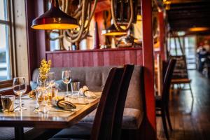 a wooden table with wine glasses and bananas on it at Nyvågar Rorbuhotell - by Classic Norway Hotels in Kabelvåg