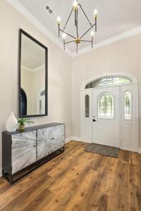 Una sala de estar con un espejo y una cómoda. en Poolside Place-Game Room-MTB-Friendly, en Bentonville