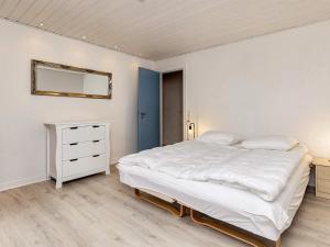 a bedroom with a large white bed and a dresser at 6 person holiday home in Ålbæk-By Traum in Ålbæk