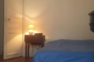 1 dormitorio con 1 cama y 1 lámpara en una mesa en Large and cosy, Paris-Ouest, en Levallois-Perret