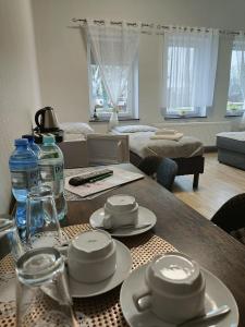 ein Wohnzimmer mit einem Tisch mit Tellern und Wasserflaschen in der Unterkunft Pałac pod Bocianim Gniazdem in Runowo