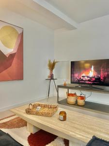 uma sala de estar com uma mesa e uma lareira em APPART'ICI Spacieux appartement F3 moderne et chaleureux em Lunel-Viel