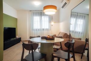 a living room with a table and chairs at Los Olivos Apartments by Olala Homes in Seville