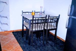 einen Esstisch mit einem schwarzen Tisch und Stühlen in der Unterkunft Airport apartment 1 