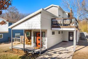 een groot wit huis met een terras en een balkon bij Porte Orange-Modern Home-1 mi from DT Fayetteville in Fayetteville