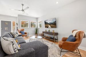 een woonkamer met een grijze bank en stoelen bij Porte Orange-Modern Home-1 mi from DT Fayetteville in Fayetteville